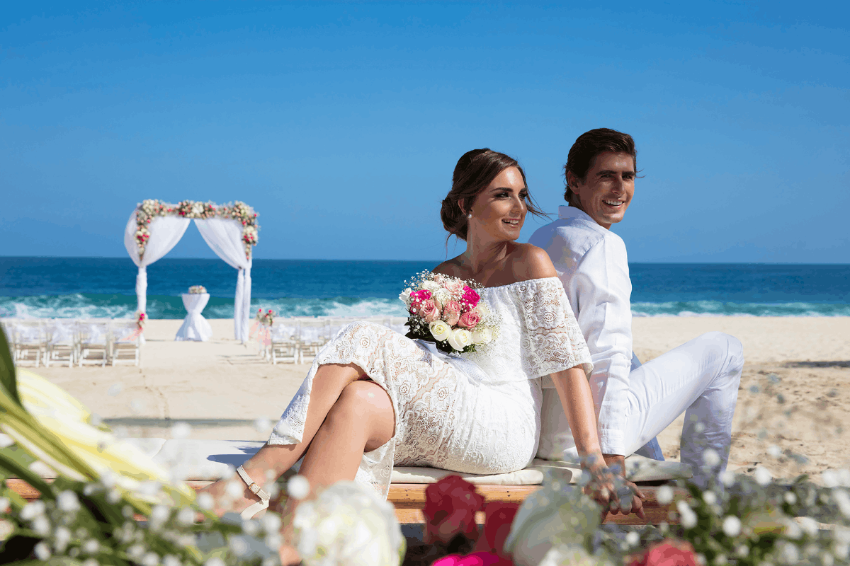 Pareja de recién casados en la playa de Krystal Grand Los Cabos con escenario romántico frente al mar.